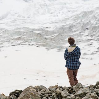 A young man feeling small while facing Chalaadi glacier. The bottom of the glacier can be reached from an easy hike starting a few kilometers after Mestia, north west of Georgia.